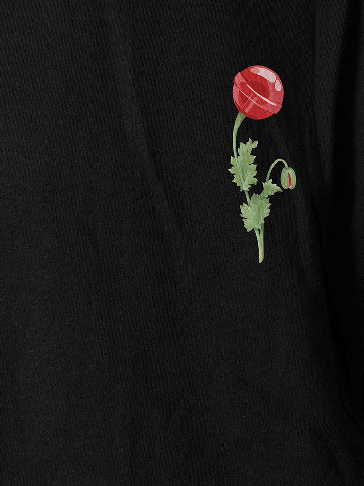 A close-up of a black printed t-shirt by useless treasures. Print of an illustrated red candy flower.