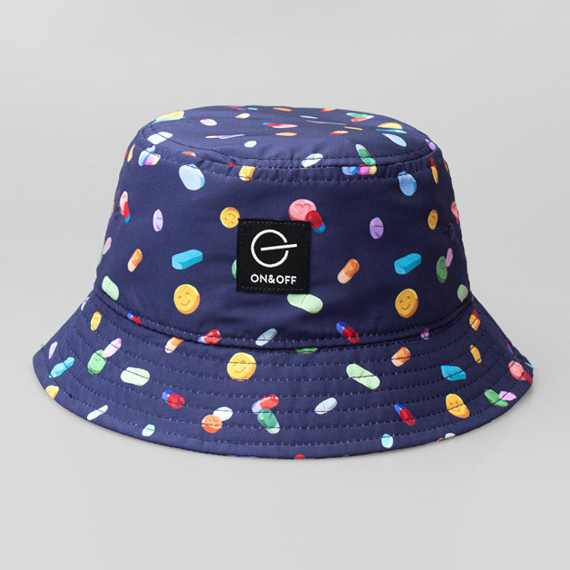 A blue On & Off x Useless Treasures bucket hat with Digital prints of drugs pills and MDMA pills; on one side of the hat is also a black label of On& Off logo- designed by useless treasures.