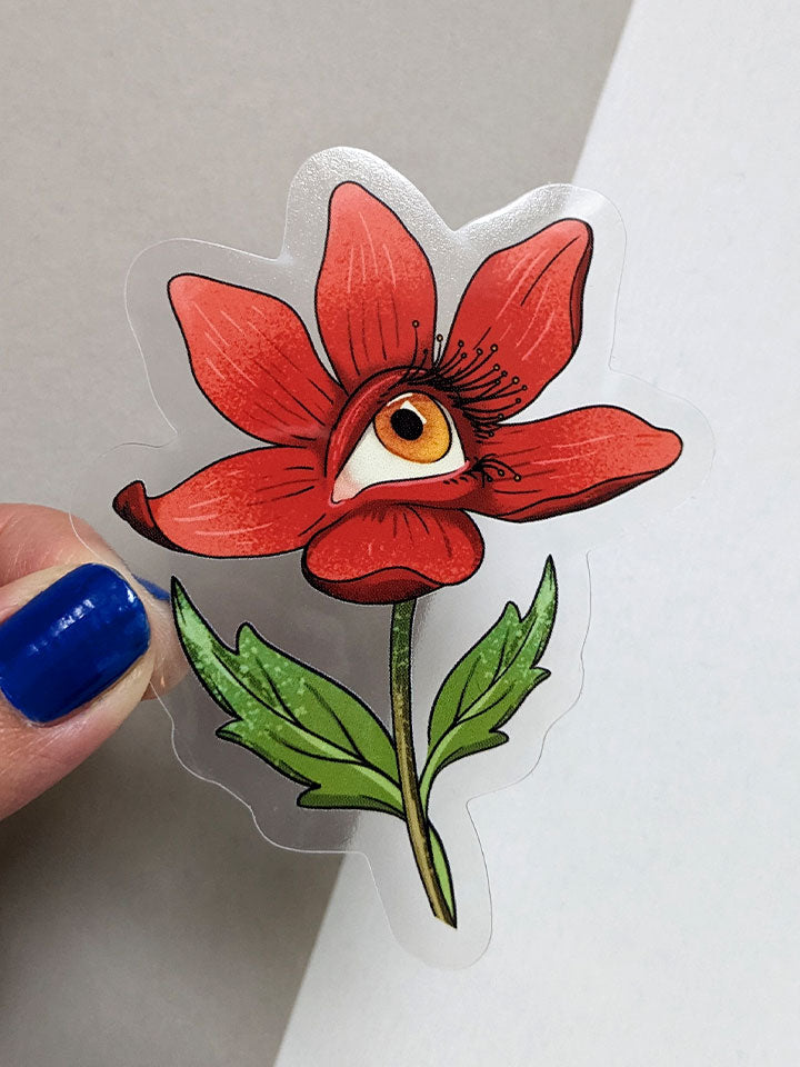 Art sticker semi-transparent material of a red flower with a human eye colored yellow. 