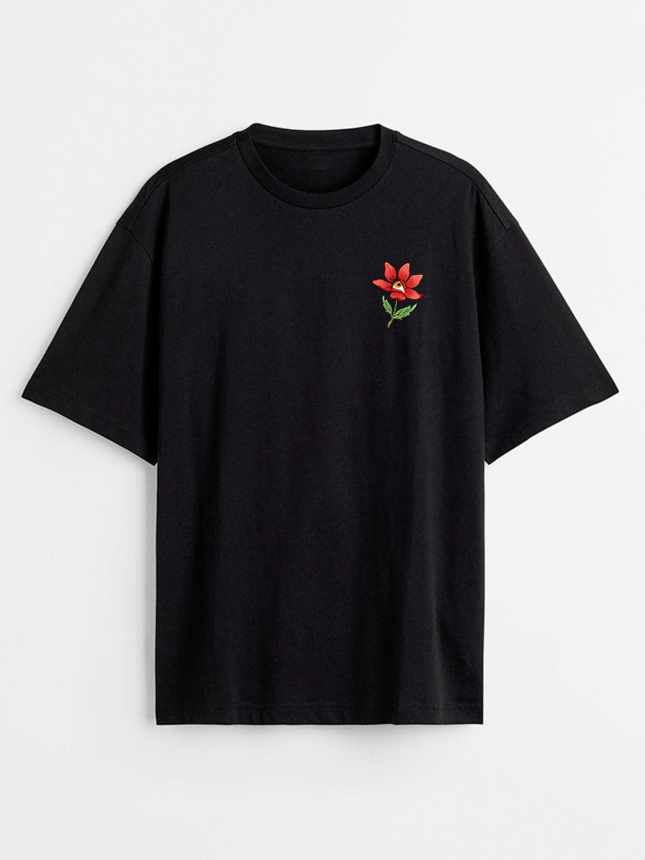 A front view of a black printed t-shirt by useless treasures. Print of an illustrated red flower with a yellow eye. 