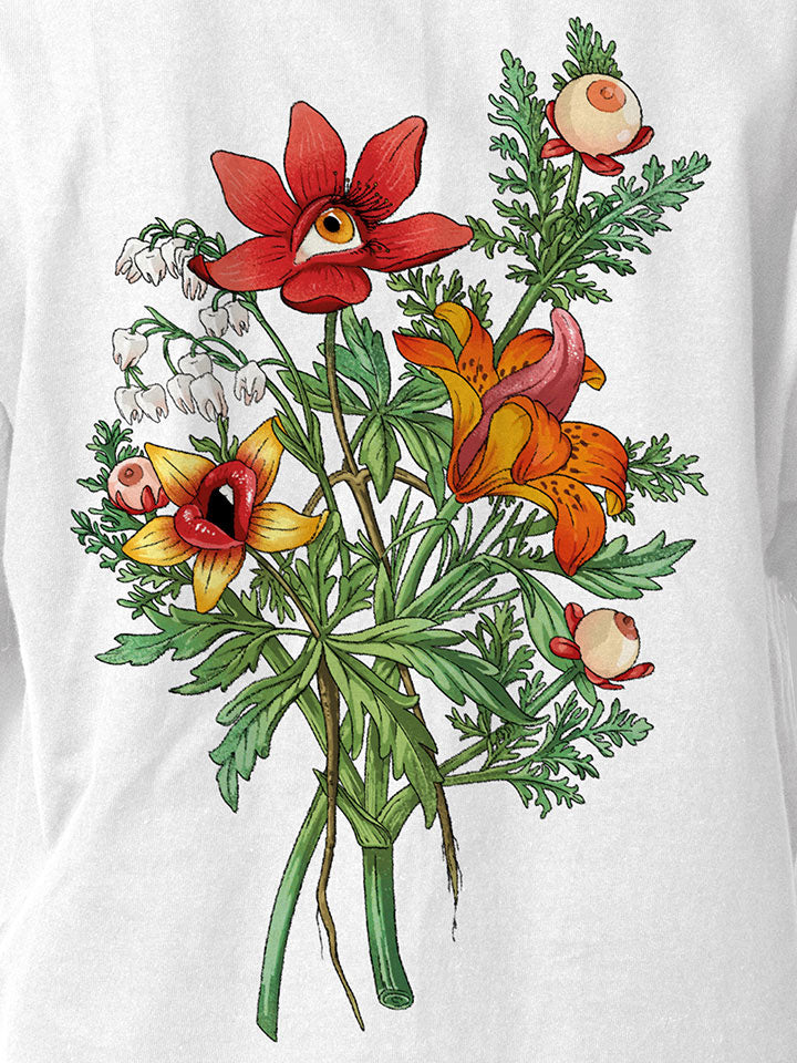 A front view of a white printed t-shirt by useless treasures. Print of an illustrated of a big bouquet of wild flowers with eyes, lips, and tongue. 