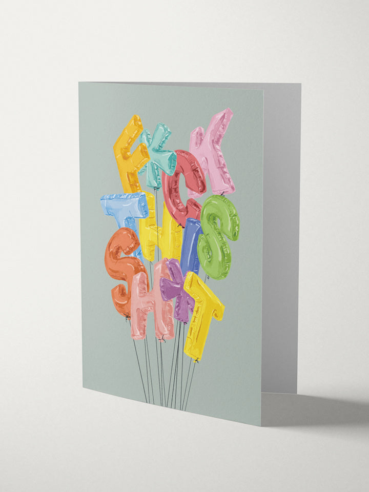 A6 greeting card with an Illustration of a bunch of strings balloons. The shape of the balloons are words that say F*ck This Sh*t on top of gray background  - Art by useless treasures  