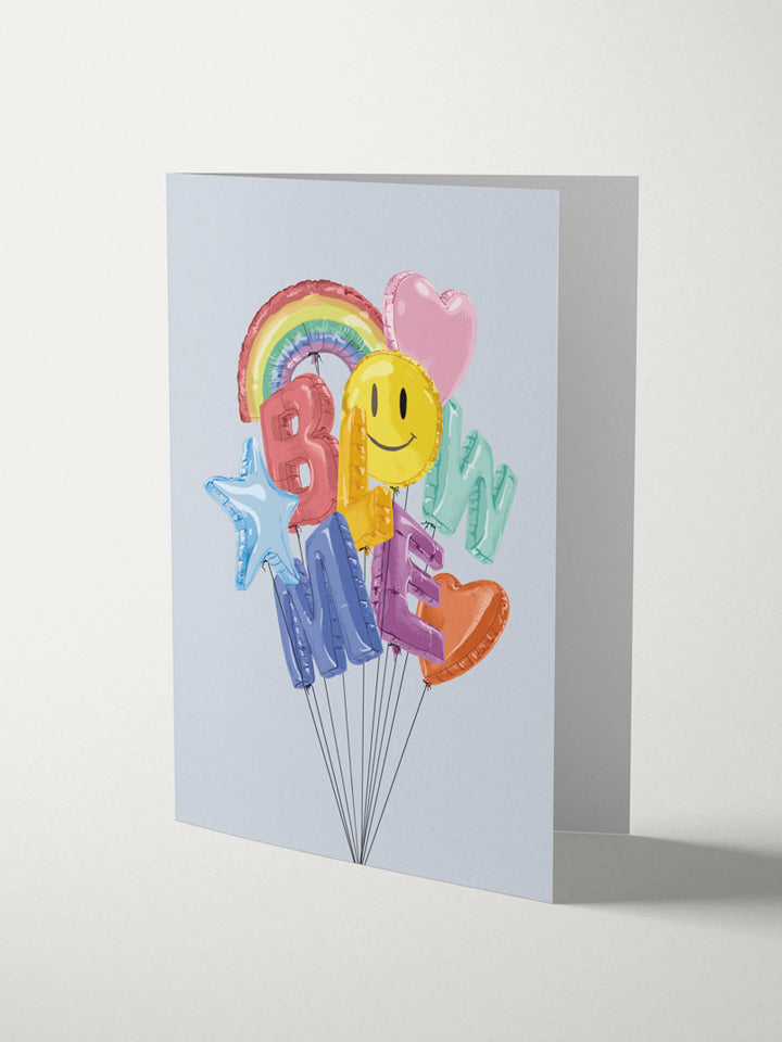 A6 greeting card with an illustration of colorful balloons with strings bonded together that says blow me; among them, there are also rainbow, smiley stars, and heart balloons - Art by useless treasures