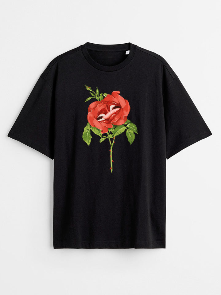 A Black oversize printed T-shirt. Short sleeve Shirt with a print called "sweet nectar" of two red roses kissing Surreal illustration by useless treasures. Organic cotton, loose fit.